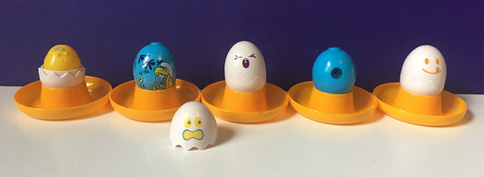 Character eggs in vintage yellow plastic egg cups